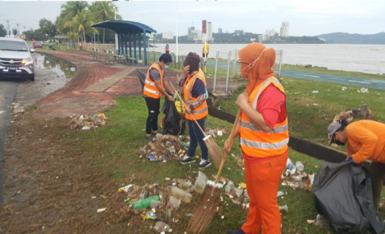 Pekerja DBKK membersihkan kawasan pantai Taman Awam Teluk Likas yang dipenuhi sampah sarap.
