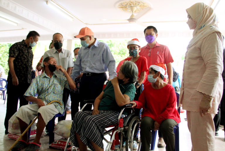 Ketua Menteri, Datuk Seri Hajiji Noor (tengah) dan isteri, Datin Seri Juliah Salag (kanan) beramah mesra dengan sebahagian daripada lebih 300 penerima pada majlis penyampaian sumbangan berupa bakul makanan dan wang tunai kepada warga emas, orang kurang upaya (OKU), ketua gereja dan pemimpin setempat sempena sambutan Hari Krismas 2021 kepada penduduk di Sulaman dan Pantai Dalit, di Kampung Serusop, di Tuaran pada Khamis.