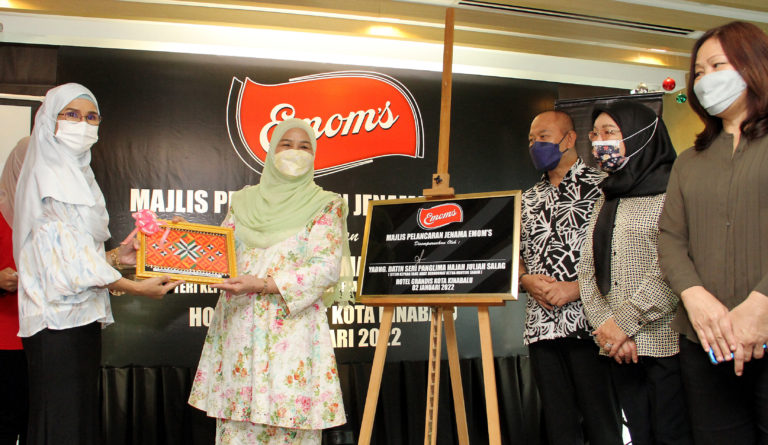 Caption Isteri Ketua Menteri, Datin Seri Panglima Hajah Juliah Salag menerima cenderahati daripada Pengarah Urusan EMOM'S Sdn Bhd, Nur Nazlyn Abdullah (kiri) sempena Majlis Pelancaran Jenama EMOM'S di Hotel Grandis, Kota Kinabalu hari ini. Turut hadir, Menteri Pembangunan Luar Bandar Sabah, Datuk Jahid Jahim (tiga dari kanan).