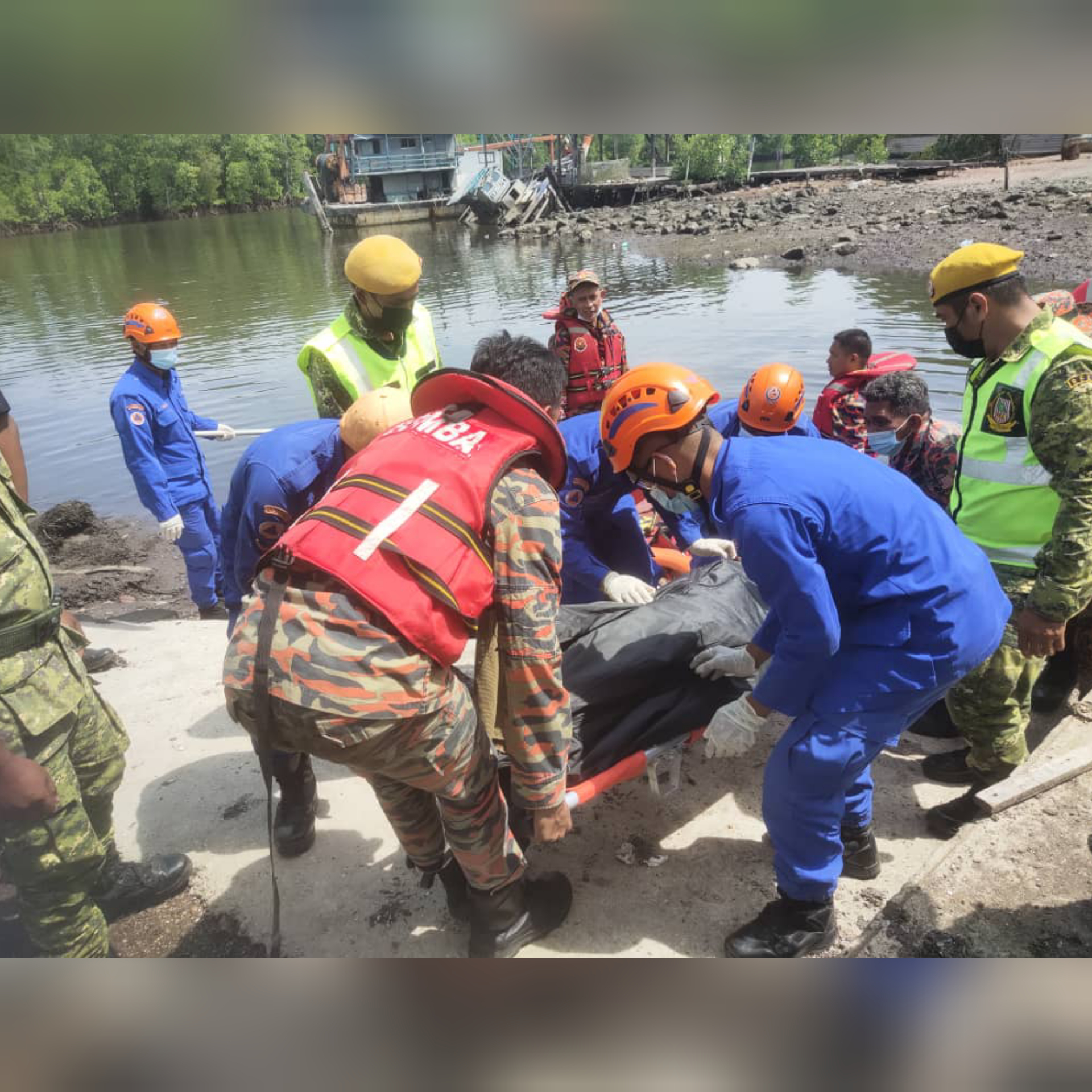 Pasukan petugas keselamatan mengangkat satu mayat mangsa terakhir bot karam di Kg Hulu Madai, Kunak pagi tadi.