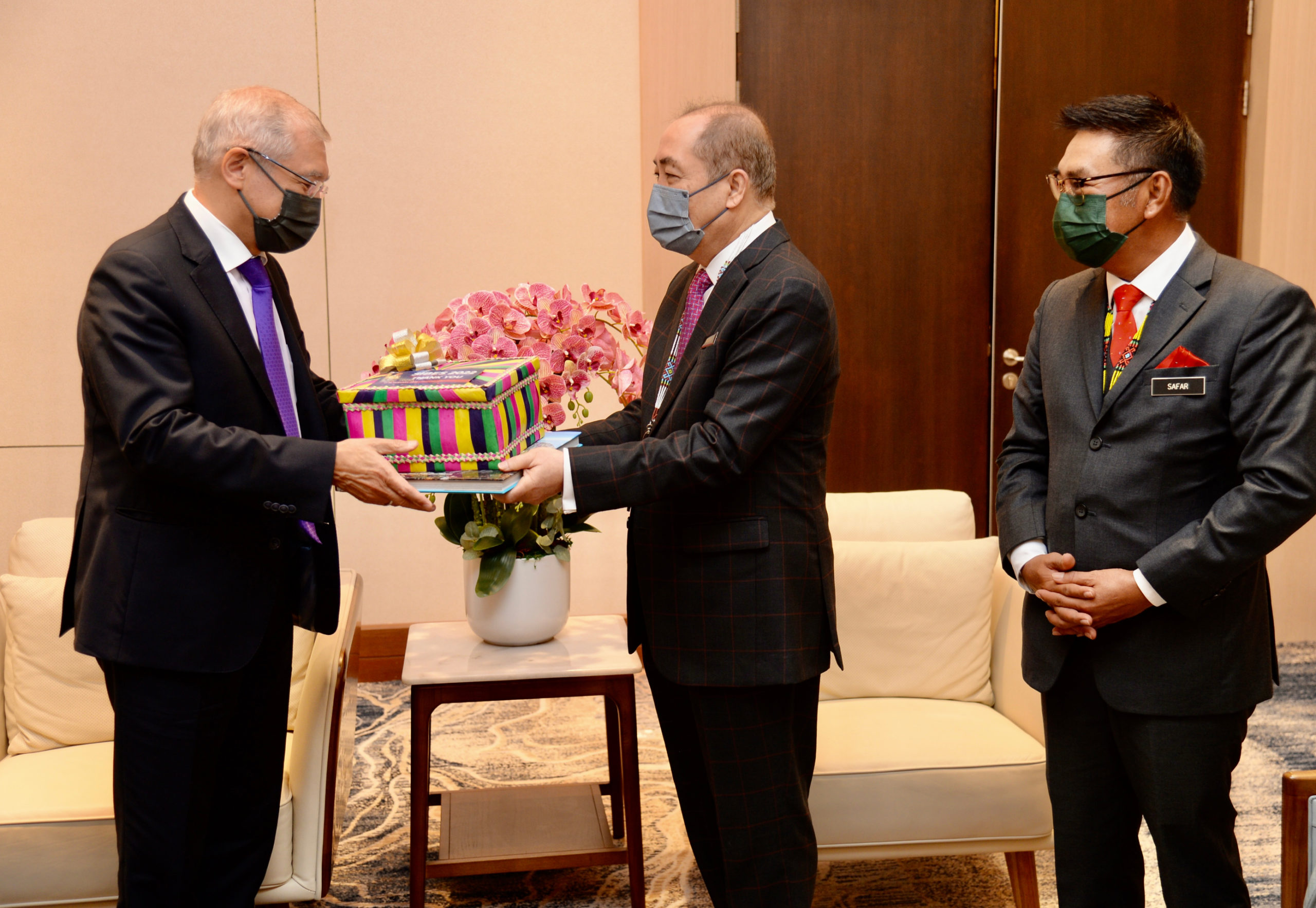 Ketua Menteri Datuk Seri Hajiji Noor (tengah) menyampaikan cenderahati kepada Duta Persekutuan Rusia ke Malaysia Naiyl M Latypov selepas kunjungan hormat selepas perasmian SIBES di SICC pada Isnin.