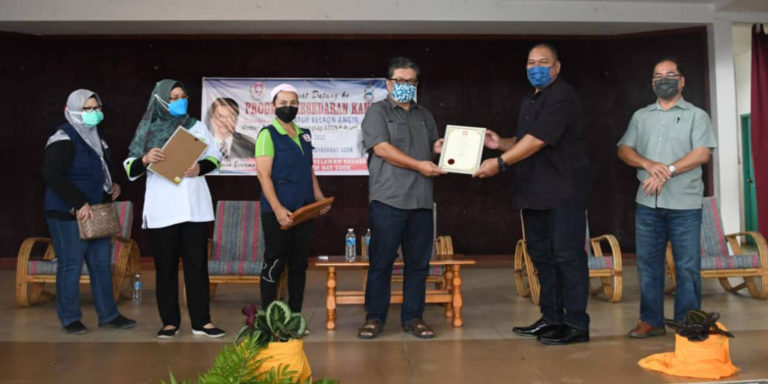 Datuk Ellron Angin Menyampaikan Sijil Penghargaan Kepada PPM Sook, Tony Talasoy sambil disaksikan oleh Penyelaras PSKS Bahagian Sook, Lucia Kihing dan Setiausaha Politiknya Jre Jrenues Pagut.