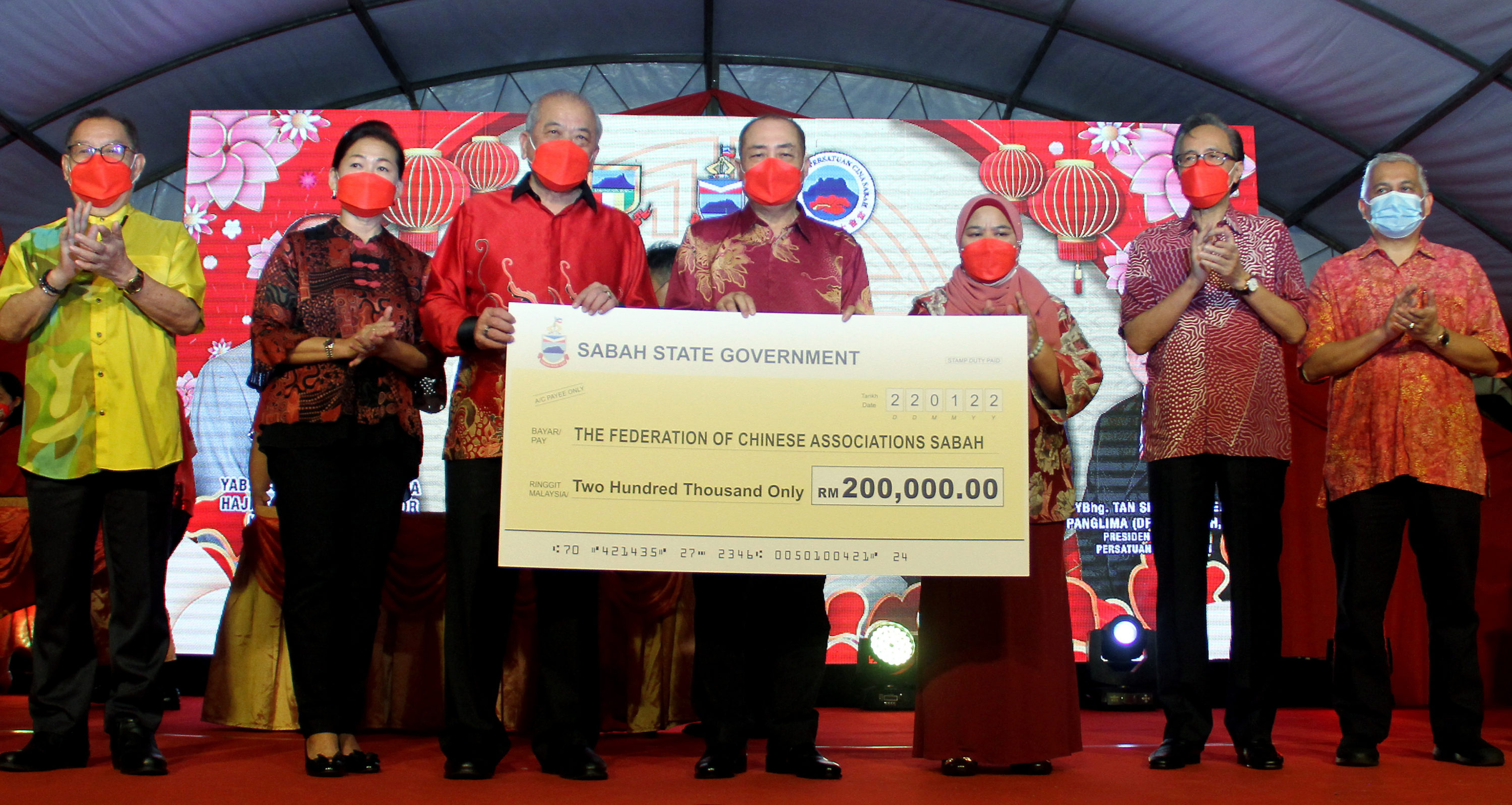 Ketua Menteri, Datuk Seri Hajiji Noor (tengah) menyerahkan replika cek RM200,000 daripada kerajaan negeri kepada Gabungan Persatuan Cina Sabah (FCAS) yang diwakili Presidennya, TC Goh pada Majlis Pembukaan Rasmi Karnival Tahun Baharu Cina 2022 di Lintasan Deasoka di sini, hari ini.