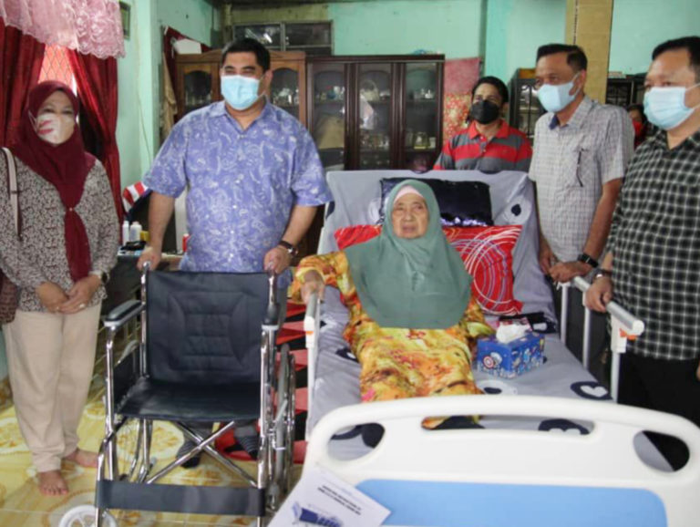 Datuk Ir. Shahelmey (dua dari kiri) menyerahkan bantuan katil boleh laras kepada salah seorang penerima di bawah program ‘Homeward’ di Putatan kelmarin.