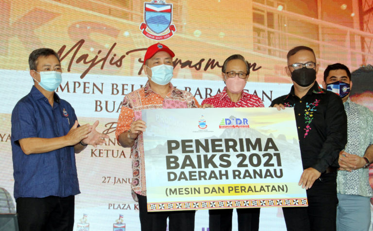 Ketua Menteri, Datuk Seri Hajiji Noor diiringi Timbalan Ketua Menteri merangkap Menteri Pembangunan Perindustrian, Datuk Dr. Joachim Gunsalam (kiri) menyerahkan geran BAIKS kepada wakil usahawan IKS Ranau sempena Majlis Perasmian Kempen Belilah Barangan Buatan Sabah di Plaza Kiaburi, Ranau, hari ini.