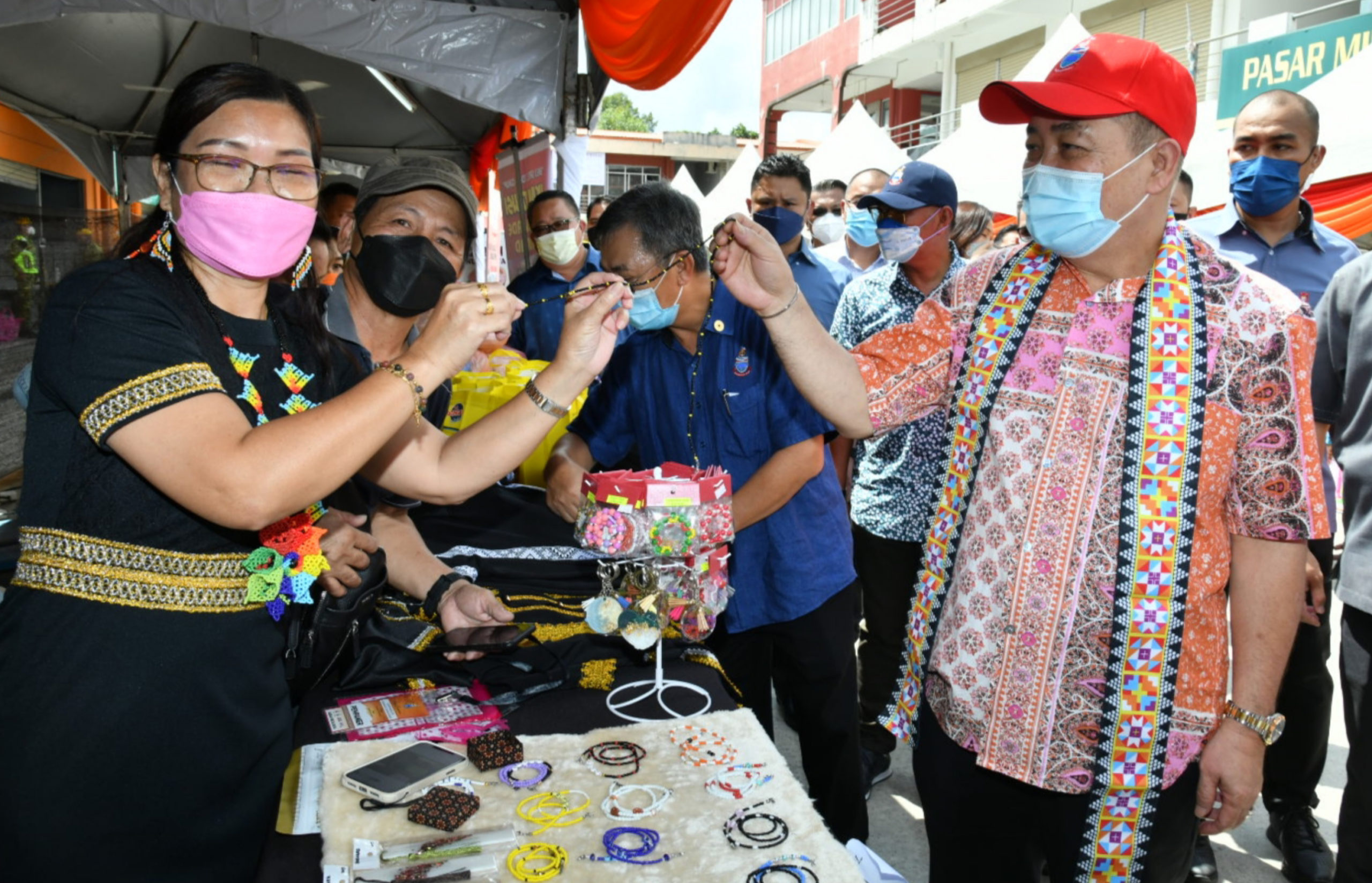 Pemilik Gerai Kimlin Besiau, memberikan Cenderamata kepada Ketua Menteri Sabah Datuk Seri Hajiji Noor ketika melawat gerai jualan sempena perasmian kempen Belilah Barangan Buatan Sabah Di perkarangan Plaza Kiaburi, Ranau, pada Khamis.