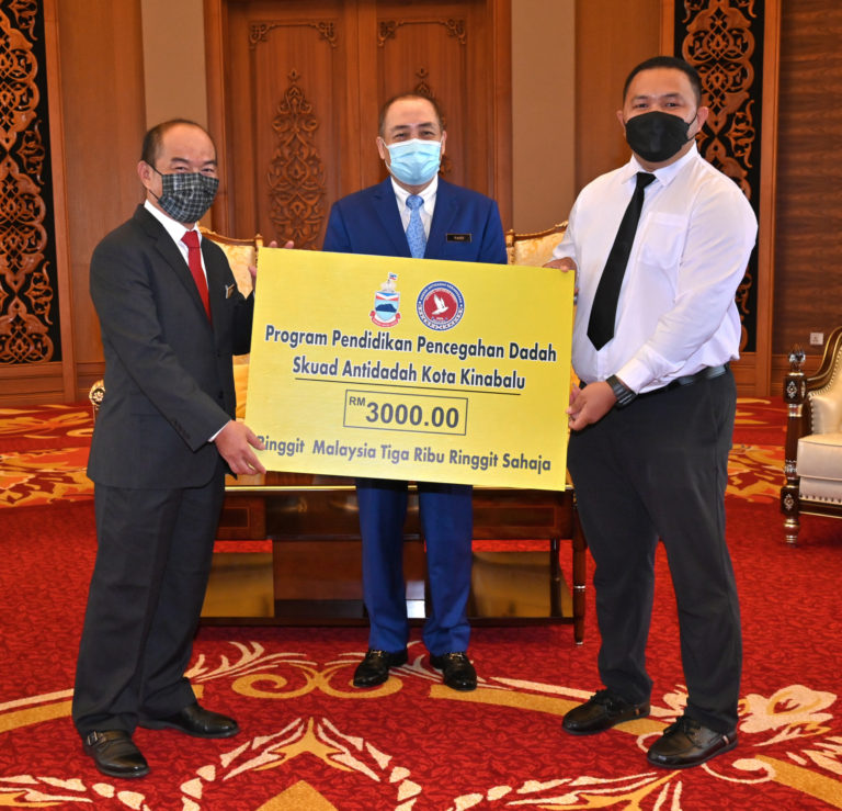 Ketua Menteri, Datuk Seri Panglima Haji Hajiji Haji Noor menyaksikan Sutekno Ahmad Belon menyerahkan sumbangan kepada Setiausaha Skuad Antidadah Kota Kinabalu, Azuan Ruzfah.