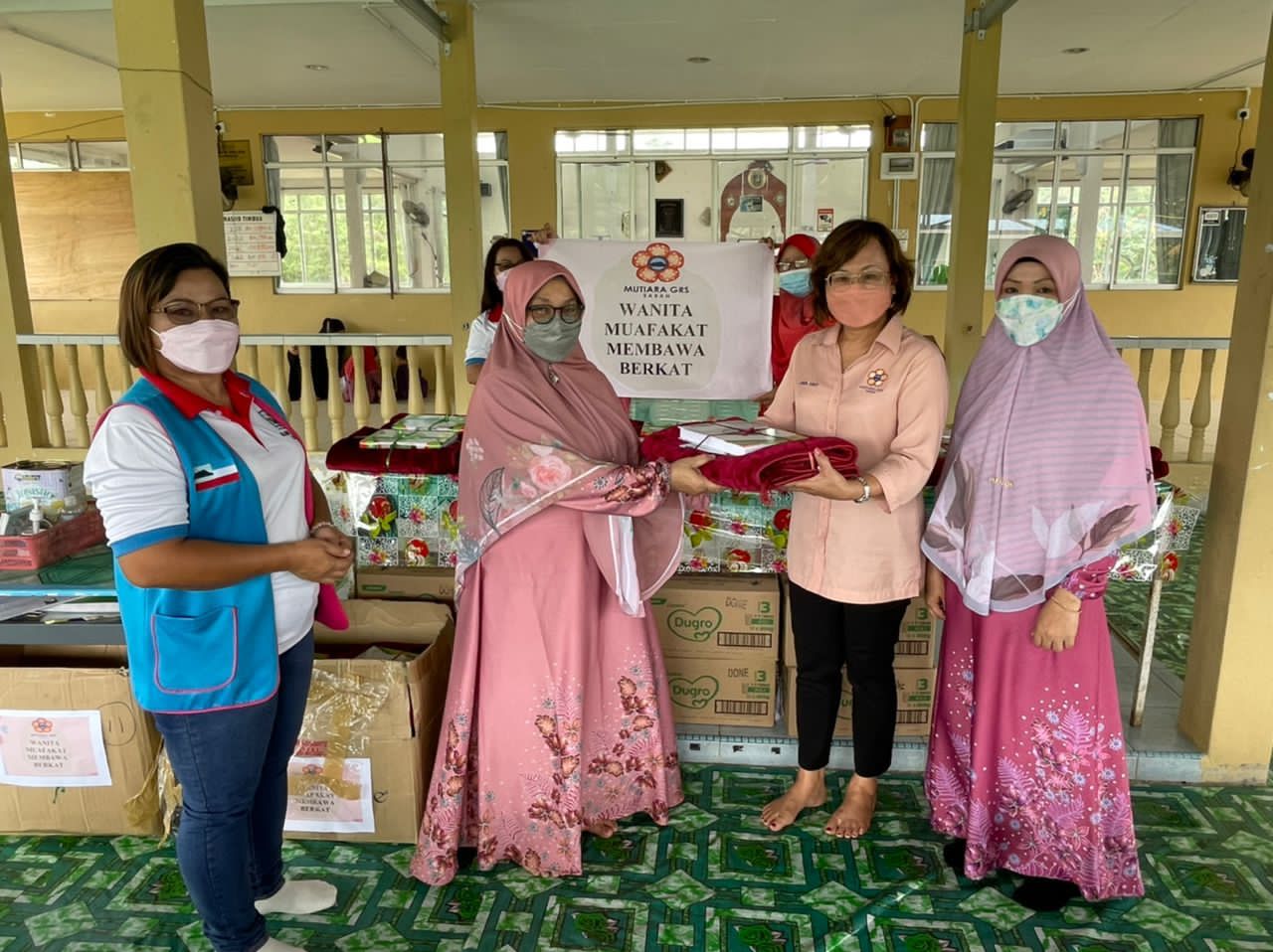 Linda (dua dari kanan) menyampaikan Al-Quran, buku Yassin dan sejadah kepada Ustazah Muna Said di Masjid Al-Syarif.