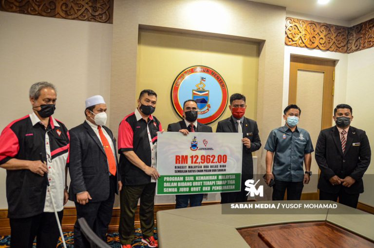 Pengarah Institut Kerjasama Kerajaan dan Rakyat, (IKRAR), Jabatan Ketua Menteri Sabah Azrul Ibrahim (tiga kanan) mewakili Ketua Menteri menyerahkan sumbangan kepada Pertubuhan Amal Pembangunan Usahawan OKU Penglihatan Malaysia (PERKUM) yang diwakili oleh Penasihat PERKUM Datuk Seri Hisham Wahab di Menara Kinabalu hari ini.