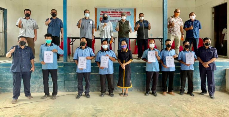 Dr. Joachim (atas, empat dari kanan) merakamkan gambar kenangan bersama dengan Ketua-ketua kampung sambil memegang Buku Adat Resam Mukim Kawiyan.