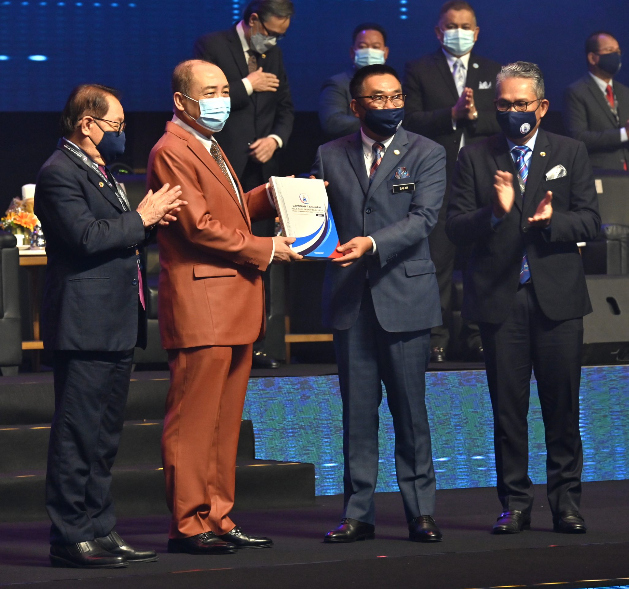 Ketua Menteri, Datuk Seri Hajiji Noor (dua kiri) menerima buku Laporan Tahunan Hala Tuju Sabah Maju Jaya (SMJ) daripada Setiausaha Kerajaan Negeri, Datuk Seri Sr. Safar Untong pada Majlis Sambutan Setahun Hala Tuju SMJ Pelan Pembangunan SMJ 1.0 (2021-2025) di Sabah International Convention Centre (SICC), Kota Kinabalu pada Selasa..