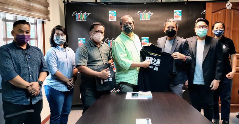 Datuk Jonstin Bangkuai (tengah) menerima barangan promosi ‘Craze Below The Wind’ daripada Chester Pang.