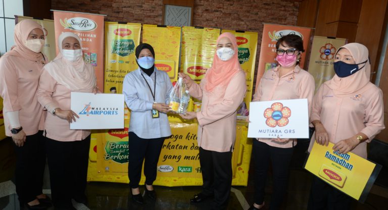 Juliah mengagihkan bubur lambuk kepada salah seorang penerima di LTAKK pada Isnin.- Foto ihsan JKM