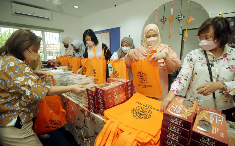 Isteri Ketua Menteri merangkap Yang Dipertua Pertubuhan Muafakat Titipan Amal Isteri Wakil Rakyat, Gabungan Rakyat Sabah (MUTIARA GRS), Datin Seri Panglima Hajah Juliah Salag (dua dari kiri) bersama ahli MUTIARA GRS membungkus kuih muih Aidilfitri untuk diagihkan kepada pasukan keselamatan dan petugas kesihatan di Rumah MUTIARA, Rose Garden, Jalan Penampang pada Sabtu.- Foto ihsan JKM