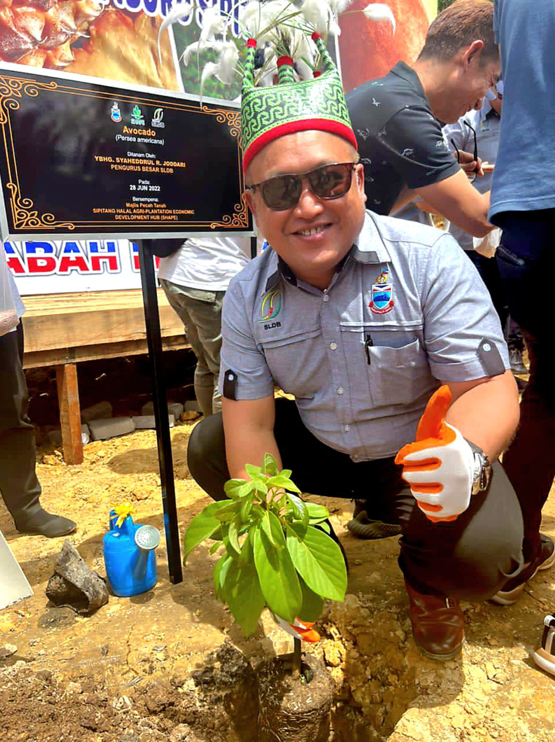 Pengurus Besar SLDB, Syaheddrul R. Joddari menanam pokok buah Avocado sempena Majlis Pecah Tanah SHAPE di Kg Iburu Sipitang.